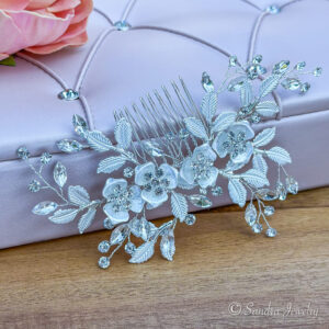 Bridal flower and leaf hair comb. Achieve the perfect wedding day look with a silver hair comb featuring a delicate blend of rhinestones, beads, and alloys.